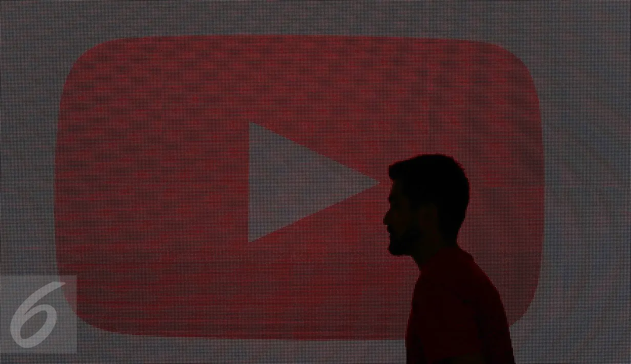 Seorang lelaki melintas di depan layar dalam acara yang diselenggarakan YouTube, Jakarta, Selasa (20/10/2015). Menurut Google Indonesia jumlah video yang diunggah pengguna YouTube Indonesia meningkat hingga 600% (Liputan6.com/Immanuel Anton)
