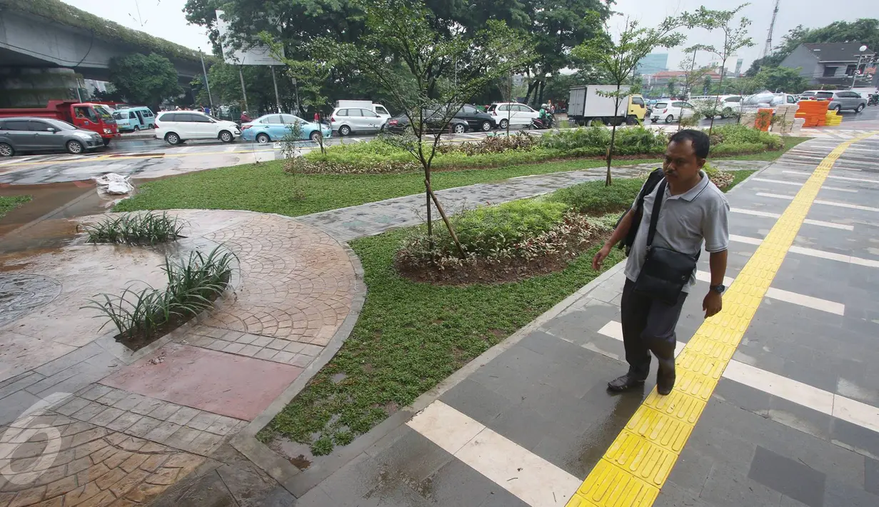 Seorang warga melintasi trotoar di Jalan Jatibaru Raya, Tanah Abang, Jakarta, Senin (21/11). Meskipun belum sepenuhnya selesai, namun trotoar yang dulu dipenuhi PKL tersebut kini telah berubah menjadi bersih dan asri. (Liputan6.com/Immanuel Antonius)