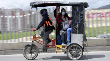 Seorang wanita menggunakan bicitaxis sebagai alternatif transportasi setelah penghancuran beberapa stasiun layanan publik selama protes terhadap pemerintah Presiden Kolombia Ivan Duque, di Bogota (24/5/2021). (AFP/ Raul Arboleda)