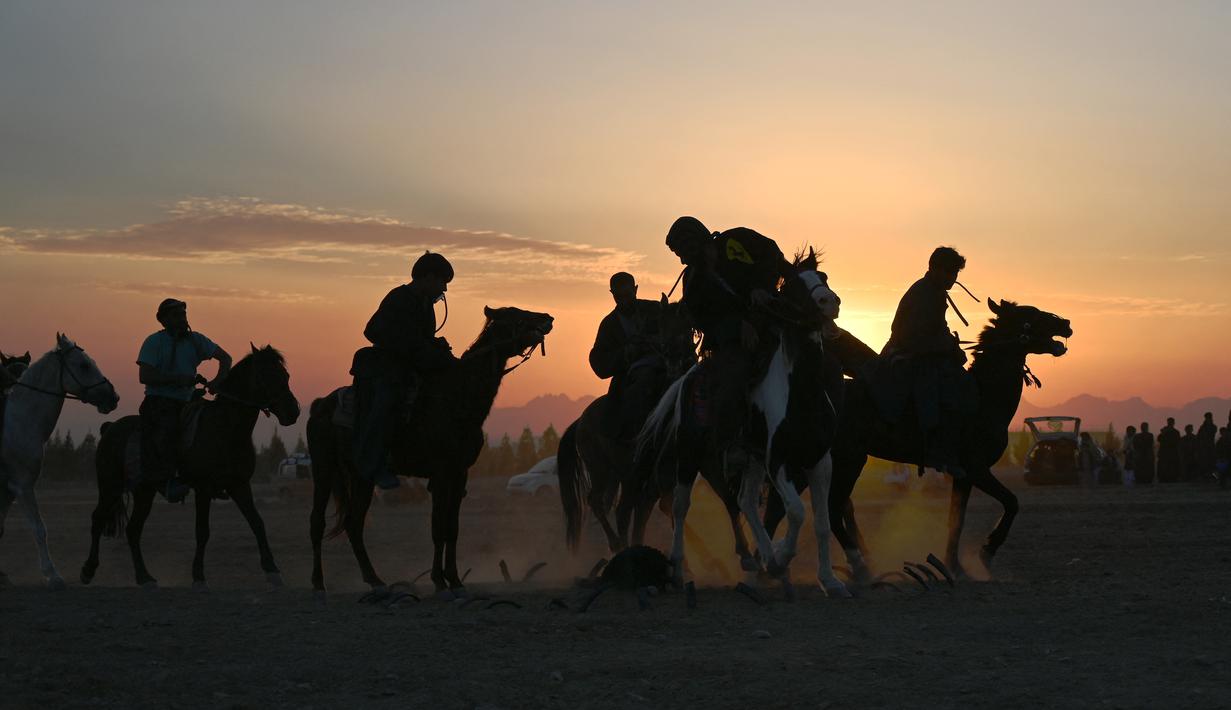 Penunggang kuda Afghanistan bersaing memperebutkan bangkai hewan dalam pertandingan Buzkashi di Herat, Afghanistan (4/2/2022). Buzkashi merupakan tradisi yang dilakukan oleh warga Afghanistan yang setiap pesertanya harus menunggang kuda. (AFP/Wakil Kohsar)