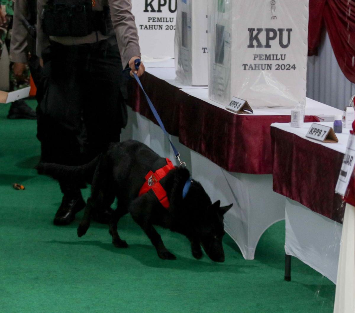 Petugas kepolisan mengerahkan K9 di TPS 033, Bojong Koneng, Kabupaten Bogor, Jawa Barat, Rabu (14/2/2024). Pengerahan anjing pelacak K9 tersebut dilakukan untuk keamanan dan kelancaran momen pencoblosan di tempat itu. Foto: Liputan6.com / Herman Zakharia