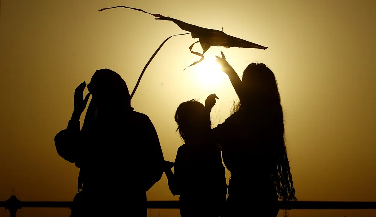 Seorang wanita saat menerbangkan layang-layang di festival layang-layang tahunan di Baghdad, Irak (5/6/2021). Festival layang-layang diadakan menarik ratusan penduduk setempat untuk menerbangkan layang-layang. (Xinhua/Khalil Dawood)