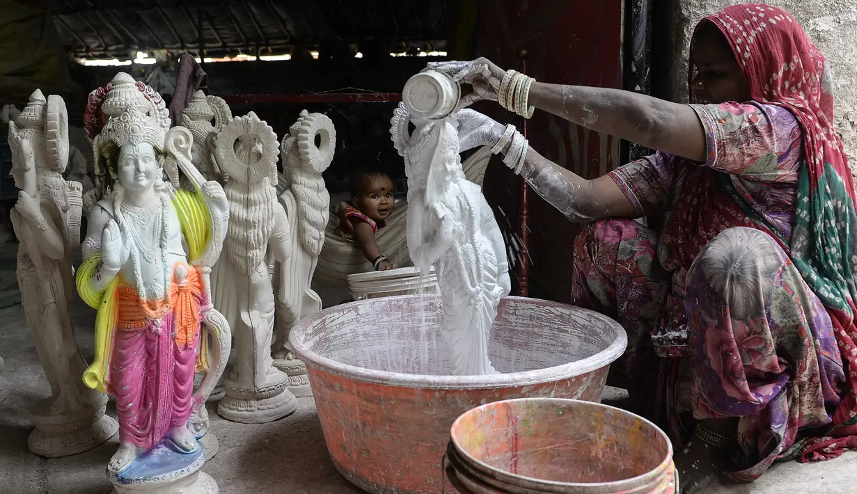 Seorang wanita memberikan warna dasar istri dewa Hindu Rama, dewi Sita di sebuah lokakarya di Hyderabad, India (15/3). Festival Rama Navami tersebut untuk merayakan kelahiran dewa Rama di seluruh India. (AFP/Noah Seelam)