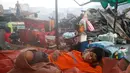 Seorang warga beristirahat ditengah reruntuhan bangunan yang hangus terbakar usai si jago merah melahap rumahnya di  Quezon, Metro Manila di Filipina (28/12). (REUTERS/Erik De Castro)