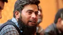 Kerabat dari korban kecelakaan pesawat Pakistan International Airlines (PIA) menangis saat menunggu tes DNA di rumah sakit PIMS di Islamabad, Pakistan, Kamis (8/12). (REUTERS / Caren Firouz)