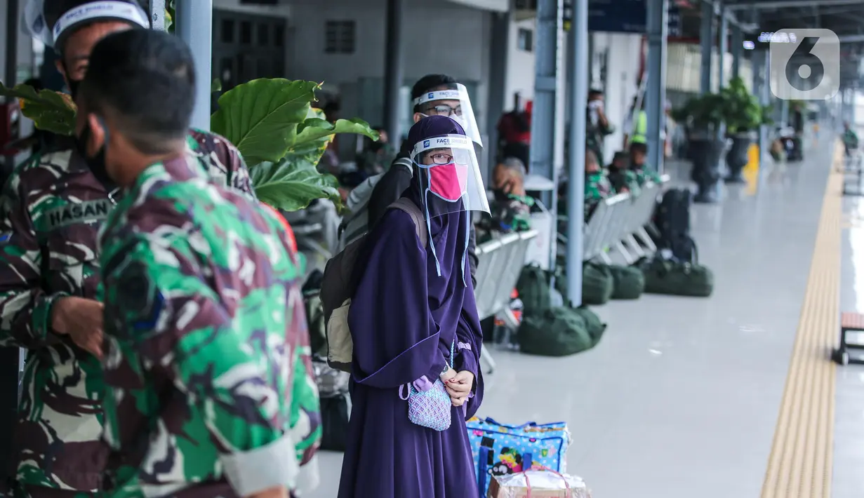 Penumpang menggunakan pelindung wajah menunggu kereta jarak jauh di Stasiun Pasar Senen, Jakarta, Jumat (10/7/2020). PT. KAI membagikan face shield kepada penumpang bertujuan memudahkan masyarakat tetap dapat menjaga physical distancing di tengah pandemi COVID-19. (Liputan6.com/Faizal Fanani)