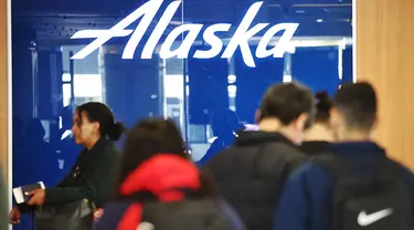 Logo Alaska Airlines ditampilkan saat pelancong berdiri di area check-in Bandara Internasional Los Angeles (LAX) di Los Angeles, California, Senin (8/1/2024). (Mario Tama/Getty Images/AFP)