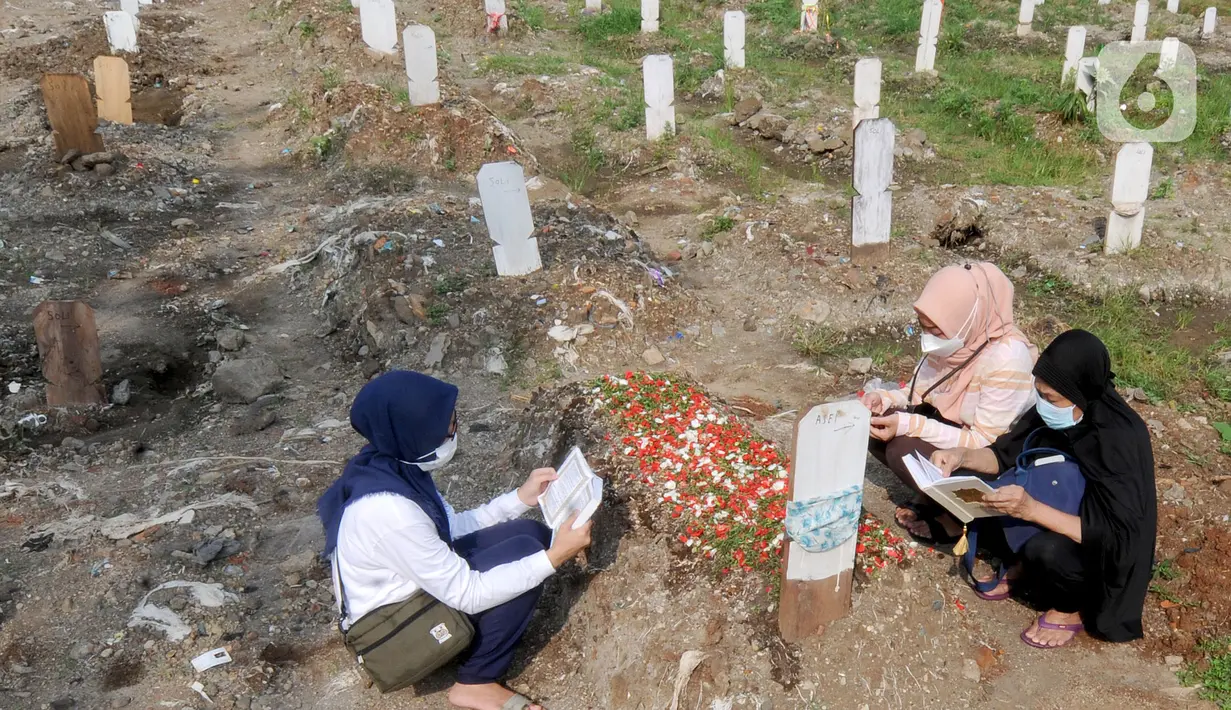Warga berdoa di depan pusara keluarganya saat ziarah kubur di TPU Srengseng Sawah 2, Jagakarsa, Jakarta Selatan, Senin (17/5/2021). Hari ini seluruh TPU di wilayah DKI dibuka untuk umum dengan menerapkan protokol kesehatan seperti pembatasan pengunjung dan waktu berziarah. (merdeka.com/Arie Basuki)