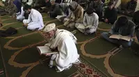 Umat muslim membaca Al-Quran selama melaksanakan salat berjemaah pada hari pertama bulan Ramadan di sebuah masjid di Kabul, Afghanistan, Jumat (24/4/2020). Mereka melaksanakan salat di tengah kekhawatiran akan penularan virus corona COVID-19. (AP Photo/Rahmat Gul)