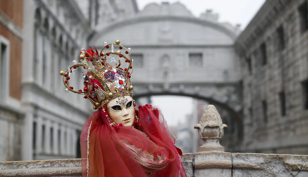 Peserta menggunakan kostum dan topeng saat mengikuti Karnaval Venesia di Piazza San Marco, Italia, Sabtu (30/1). Dalam acara tahunan ini, peserta mengenakan kostum ala Venesia abad ke-18 dan topeng-topeng unik menutupi wajah (REUTERS/Alessandro Bianchi)