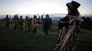 Anggota Powderkeg Morris Dancers menari di atas Windgather Rocks di High Peak di Derbyshire sebelum matahari terbit (1/5). Mereka melakukan tarian tahunan sebagai bagian dari festival Celtic kuno. (AFP Photo/Lindsey Parnaby)