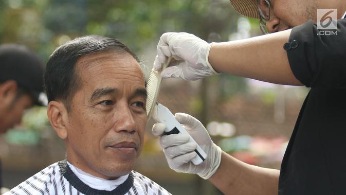 Presiden Joko Widodo saat mengikuti acara cukur rambut massal di Garut, Jawa Barat, Sabtu (19/1). Tak hanya Jokowi, Menteri PUPR Basuki Hadimuljono serta Kepala Sekretariat Presiden Heru Budi Hartono  ikut memangkas rambutnya. (Liputan6.com/Angga Yuniar)