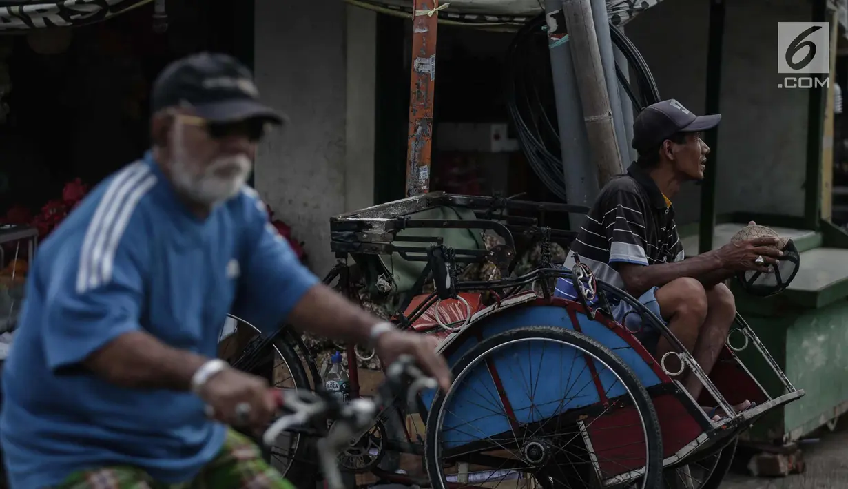 Tukang becak menunggu penumpang di Kampung Bahari, Tanjung Priok, Jakarta, Selasa (16/1). Keberadaan becak  aktifitasnya kucing-kucingan dengan petugas satpol PP ini akan dilegalkan operesionalnya oleh Gubernur Anies Baswedan. (Liputan6.com/Faizal Fanani)