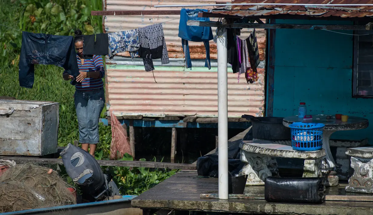 Seorang wanita menggantung pakaian di luar rumah panggungnya di Congo Mirador, Venezuela, pada 6 September 2021. Kehidupan indah di Congo Mirador, sebuah desa rumah panggung yang tampak mengapung di perairan laguna di Zulia (barat), tenggelam dalam lumpur dan gulma. (Federico PARRA/AFP)