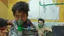 Seorang anak mendapat bantuan pernapasan usai menghirup senjata kimia di Al-Shifuniyah, Ghouta Timur, Damaskus, Suriah, Minggu (25/2). Kementerian Kesehatan Pemerintah Sementara Suriah menyebut, bau klorin tercium usai ledakan besar. (HAMZA AL-AJWEH/AFP)