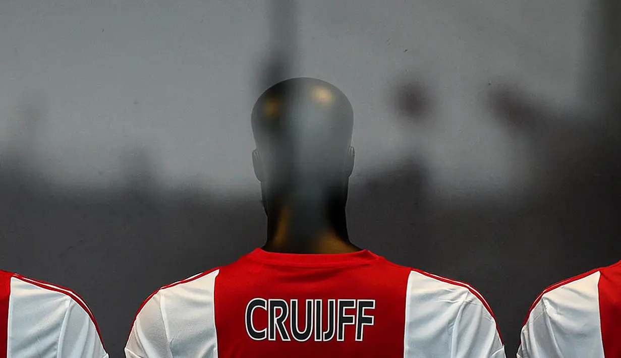 Toko Ajax Fanshop memasang jersey bernama Cruyff yang berada di sekitar Stadion Amsterdam Arena, Amsterdam, Kamis (24/3/2016). Legenda sepak bola dunia, Johan Cruyff, meninggal dunia pada Kamis (24/3/2016) karena sakit kanker. (AFP/Franck Fife)