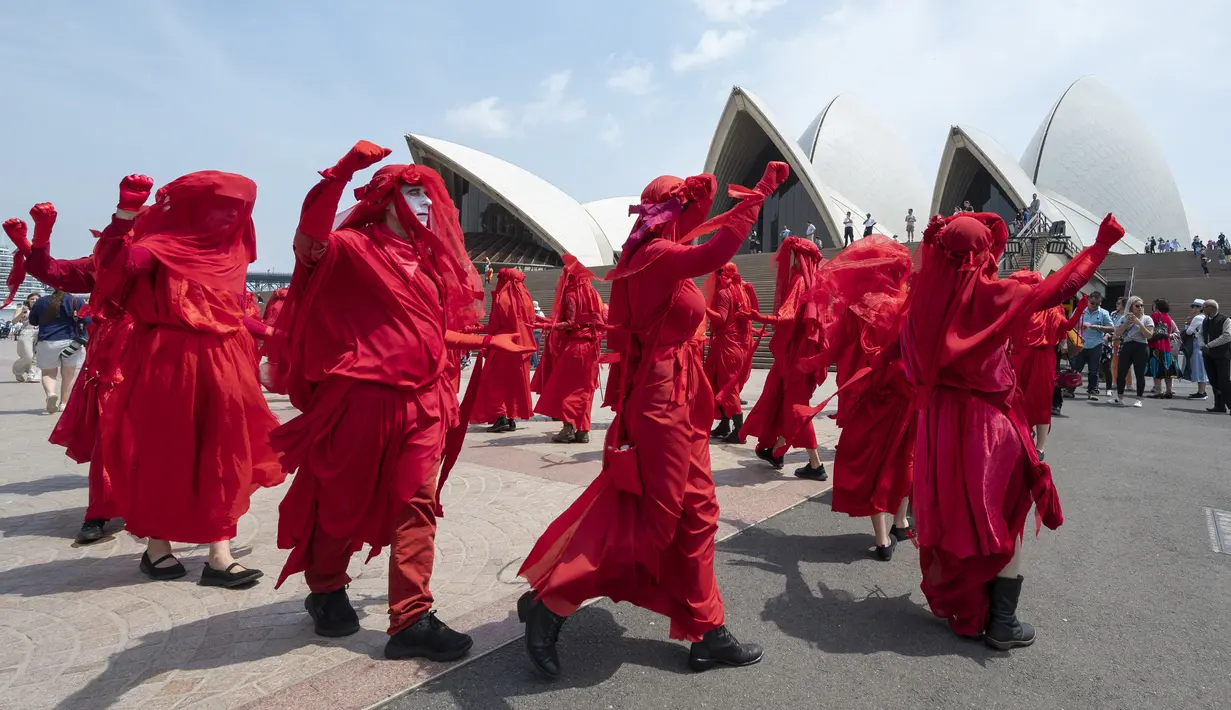 Aktivis yang terbagung dalam kelompok Red Rebels berunjuk rasa dalam demonstrasi protes iklim di Sydney (15/12/2019). Pengunjuk rasa melakukan aksi di depan landmark Gedung Opera Sydney menuntut pemerintah Australia menanggulangi asap yang menyebabkan masalah kesehatan. (AFP/Wendell Teodoro)