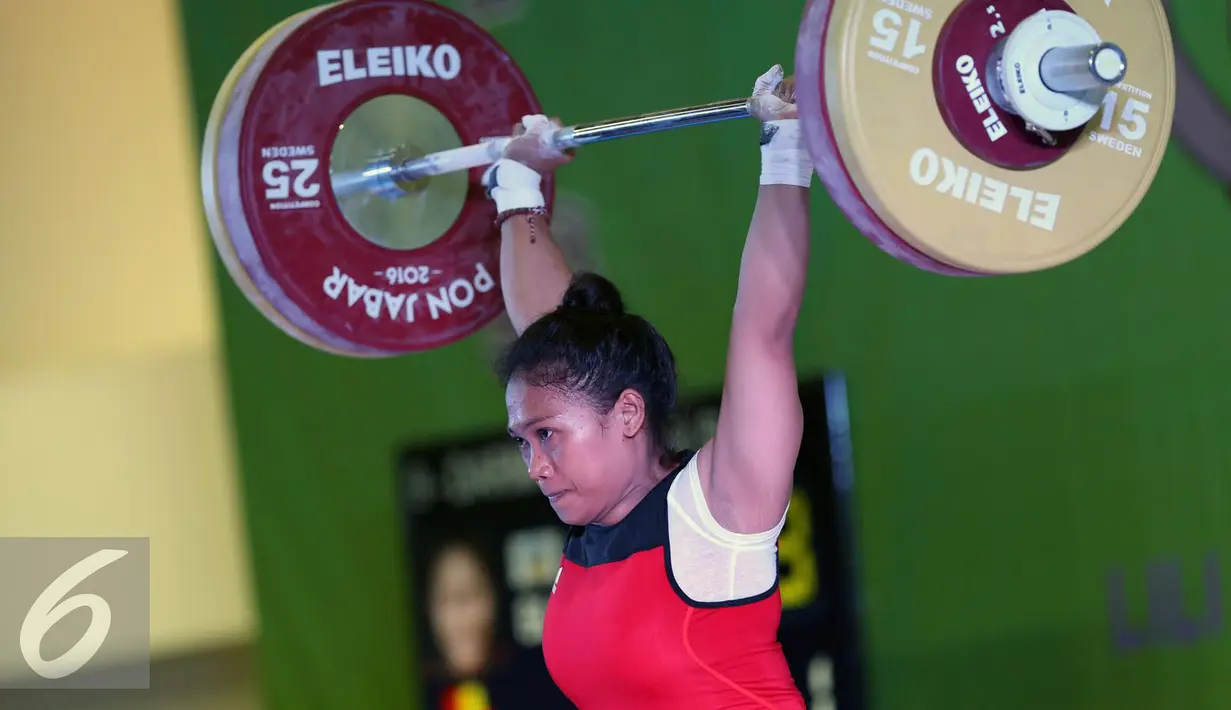 Lifter Bali, Sinta Luh Darmariani saat melakukan angkatan clean and jerk di kelas 63kg putri PON XIX Jabar di Gymnasium Si Jalak Harupat, Kab Bandung, Rabu (21/9). Sinta meraih emas dengan total angkatan 192kg. (Liputan6.com/Helmi Fithriansyah)