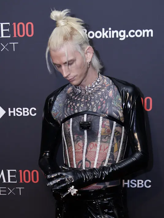 <p>Machine Gun Kelly saat menghadiri Time100 Next Gala di SECOND Floor, New York City, Amerika Serikat, 25 Oktober 2022. Machine Gun Kelly mengenakan potongan busana formal yang khas dan membuat tampilan tersebut lebih punk-rock. (Kena BETANCUR/AFP)</p>
