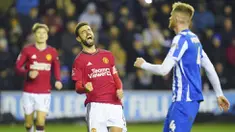 Pemain Manchester United, Bruno Fernandes, melakukan selebrasi setelah mencetak gol ke gawang Wigan Athletic dalam laga putaran ketiga FA Cup 2023/2024 di DW Stadium, Selasa (9/1/2024) dini hari WIB. MU menang dengan skor 2-0. (AP Photo/Jon Super)