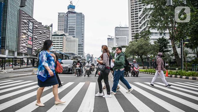 Pejalan kaki menyeberang jalan di kawasan Sudirman, Jakarta Pusat, Rabu (6/1/2021). Pemerintah memberlakukan kebijakan pembatasan sosial berskala besar (PSBB) di wilayah Jawa dan Bali mulai 11 hingga 25 Januari 2021 menyusul lonjakan kasus Covid-19 di sejumlah daerah. (Liputan6.com/Faizal Fanani)