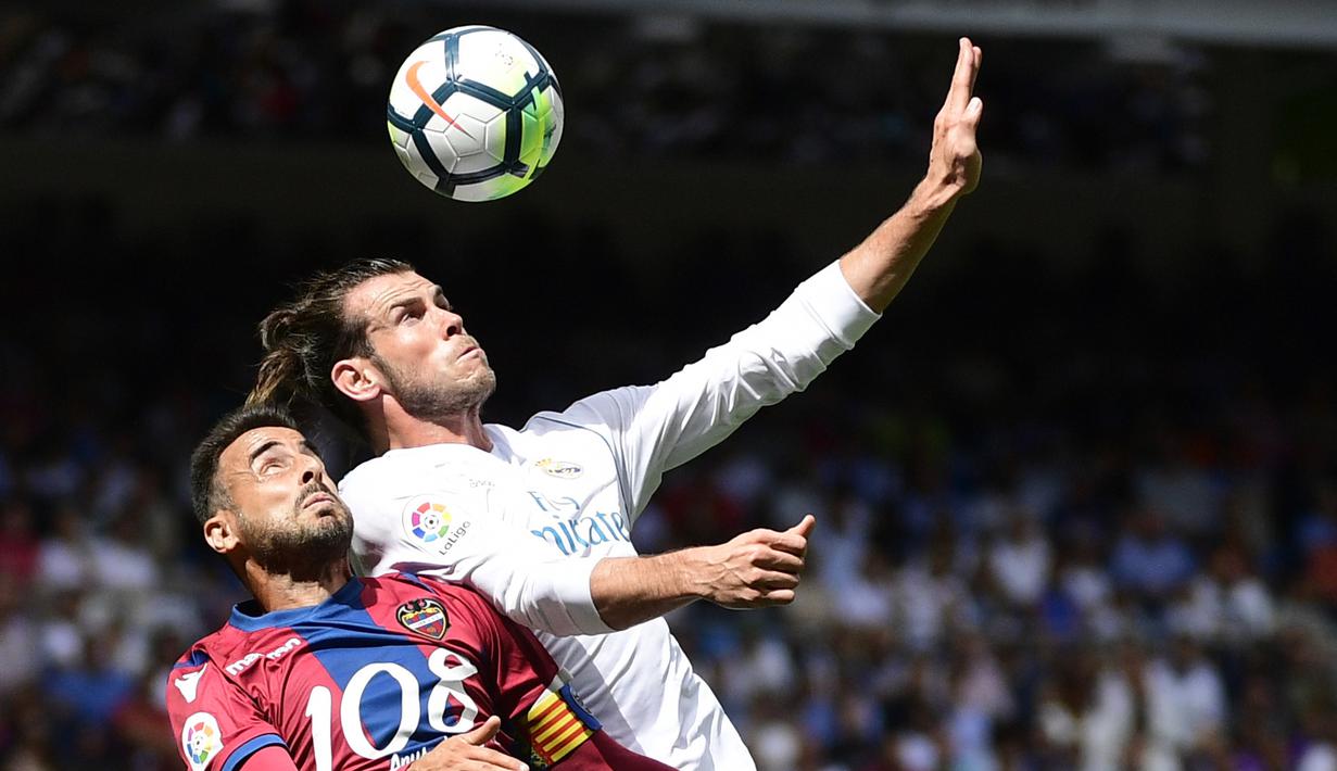 Pemain Levante, Pedro Lopez (kiri) berebut bola dengan pemain Real Madrid, Gareth Bale pada lanjutan La Liga di Santiago Bernabeu stadium, Madrid (9/9/2017). Madrid bermain imbang 1-1. (AFP/Pierre-Philippe Marcou)