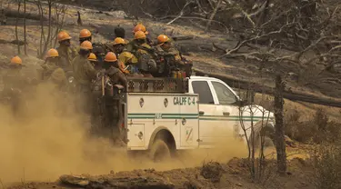 Petugas pemadam kebakaran Los Padres Hotshots naik ke lokasi baru untuk memotong jalur api di Oak Fire dekat Mariposa, California, Amerika Serikat, 26 Juli 2022. Petugas pemadam kebakaran membuat kemajuan dalam memerangi kebakaran hutan musim panas terbesar di California. (DAVID MCNEW/AFP)