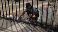 Salah satu petugas kebersihan di Stadion Pakansari membersihkan botol mineral yang disita panpel pertandingan semifinal Piala AFF 2016, Indonesia Vs Vietnam. (Bola.com/Benediktus Gerendo)