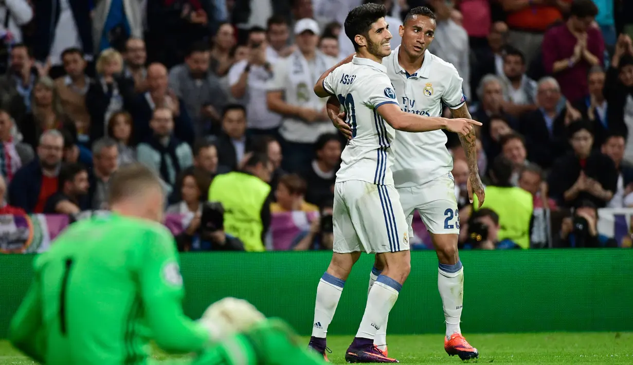 Gelandang Real Madrid Marco Asensio melakukan selebrasi bersama bek Danilo usai mencetak gol kegawang Legia Warsawa pada Liga Champion di stadion Santiago Bernabeu, Spanyol, (18/10). (AFP Photo/Pierre-Philippe Marcou)