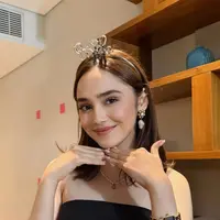 Dalam foto tersebut, Syifa tampil simpel namun tetap elegan dalam balutan bandeau top hitam yang memberi kesan sleek dan modern. Pilihan busana tanpa banyak detail ini justru menonjolkan pesona naturalnya, sekaligus memberi ruang bagi aksesori untuk tampil sebagai statement utama. [@elrumi_syifa25].