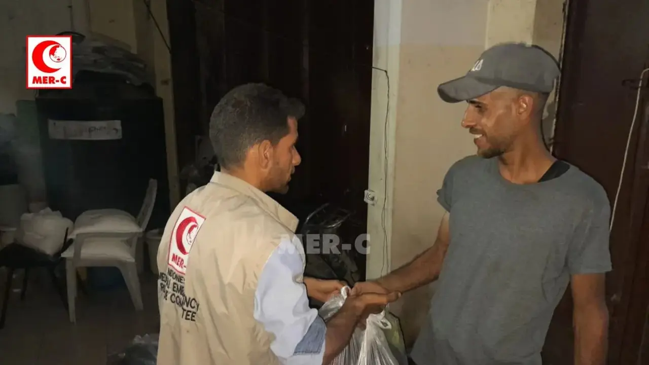 Relawan MER-C membagikan paket bantuan makanan kepada warga di Gaza. (MER-C)