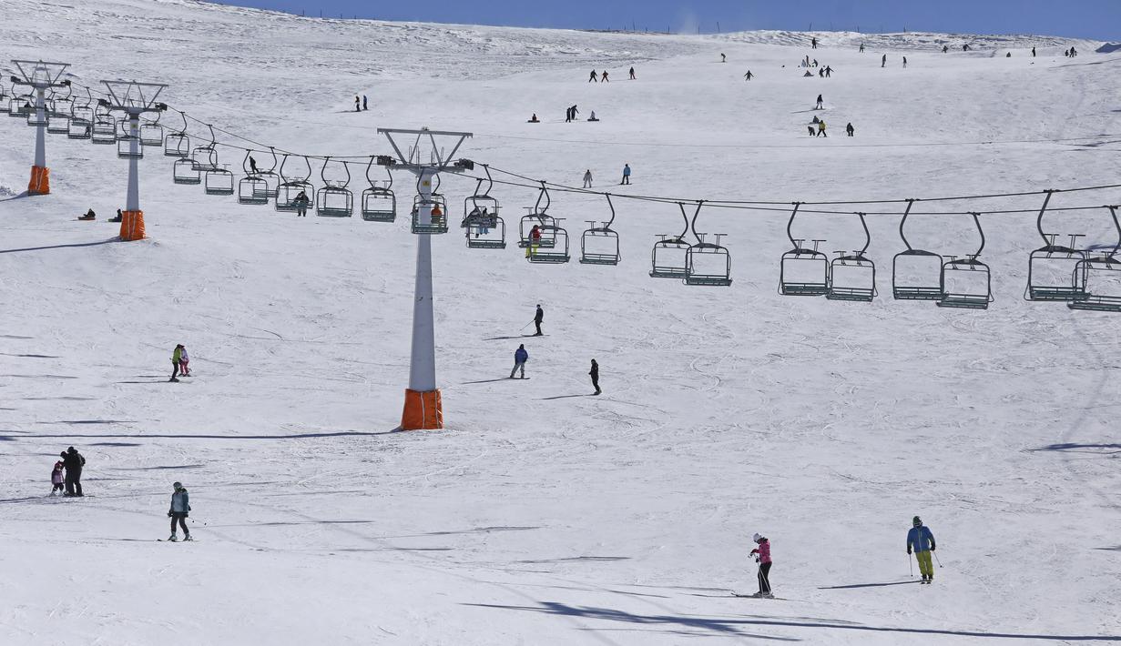 Pemain ski Iran menuruni lereng di resor ski Tochal di luar ibu kota Teheran, Iran (1/1/2022). Di tengah polusi udara dan kesengsaraan ekonomi, penduduk Teheran menemukan kenyamanan di resor ski di utara Teheran di pegunungan Alborz. (AP Photo/Vahid Salemi)