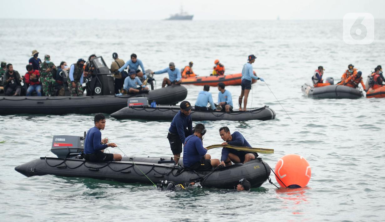 Tim SAR mengevakuasi potongan pesawat Sriwijaya Air SJ 182 di perairan Kepulauan Seribu, Jakartra, Minggu (10/1/2021). Sriwijaya Air SJ 182 hilang kontak empat menit usai lepas landas dari Bandara Soetta. (merdeka.com/Arie Basuki)