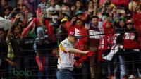Marc Marquez bersiap melempar kaus ke arah fans yang memadati tribun Sirkuit Sentul, Bogor, Minggu (14/2/2016). (Bola.com/Nicklas Hanoatubun)