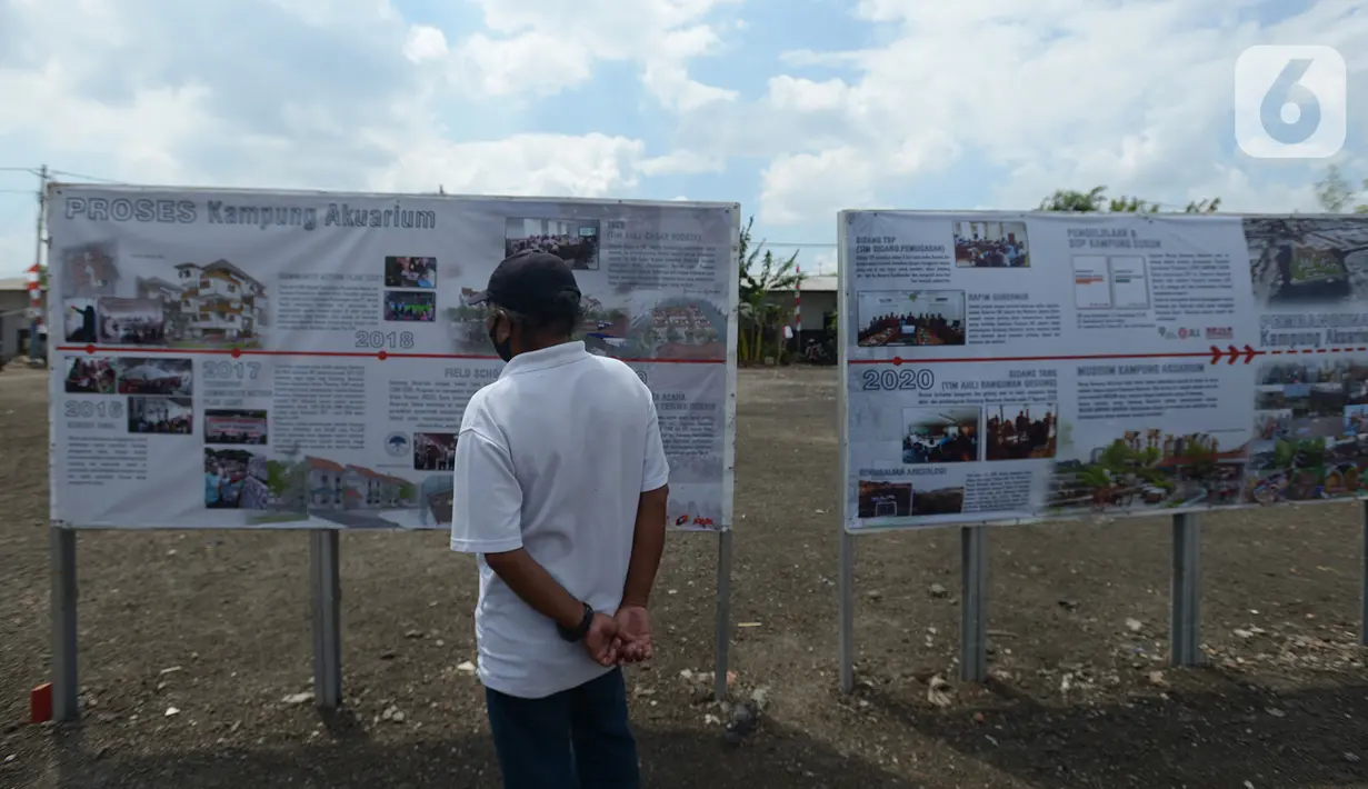 Warga melihat peta pembangunan Kampung Akuarium di wilayah Penjaringan, Jakarta Utara, Jumat (21/8/2020). Pembangunan kampung susun Akuarium nantinya dibangun di tanah seluar 10.300 meter persegi dengan total 241 unit hunian. (merdeka.com/Imam Buhori)