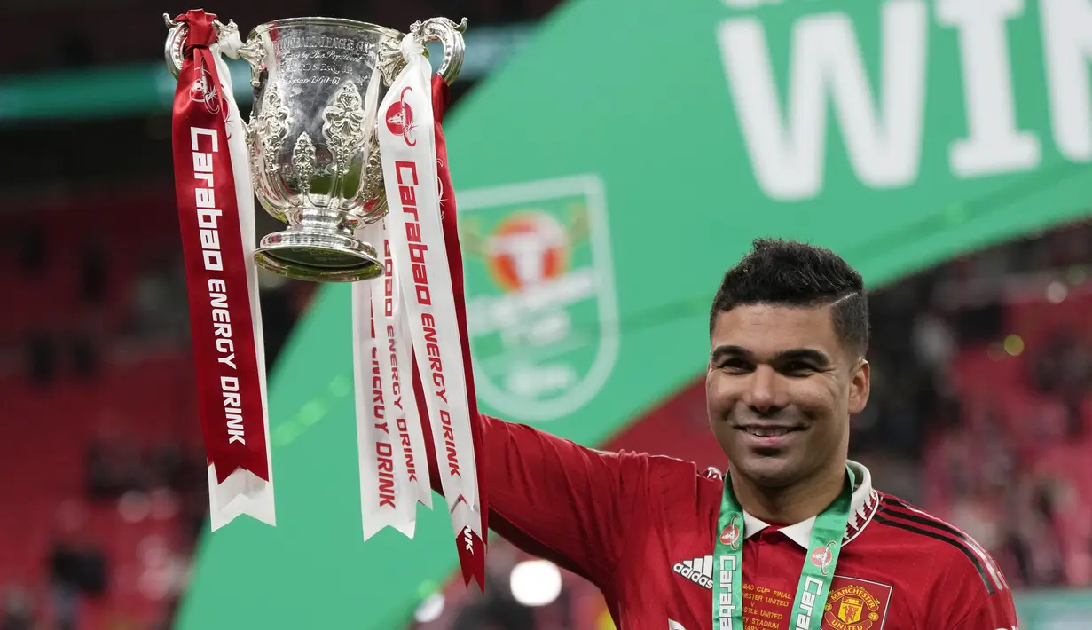 <p>Gelandang Manchester United, Casemiro memegang trofi Carabao Cup 2022/2023 selama perayaan juara usai mengalahkan Newcastle United pada laga final di Stadion Wembley di London, Senin dini hari WIB (27/2/2023). Manchester United atau MU menang 2-0 atas Newcastle United di final Carabao Cup 2022/2023. (AP Photo/Alastair Grant)</p>