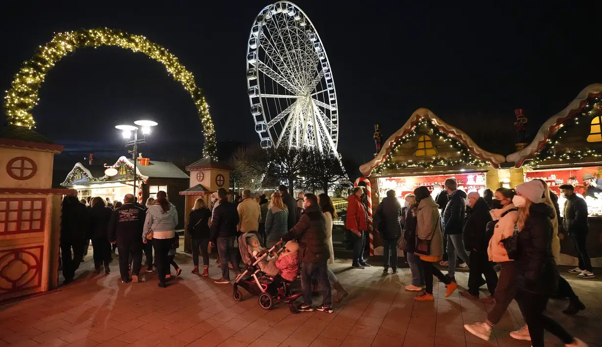 Orang-orang mengunjungi pembukaan pasar Natal besar di pusat perbelanjaan Westfield Centro di Oberhausen, Jerman, Jumat (12/11/2021).  Pasar di Oberhausen juga mewajibkan pengunjung untuk tetap memakai masker. (AP Photo/Martin Meissner)