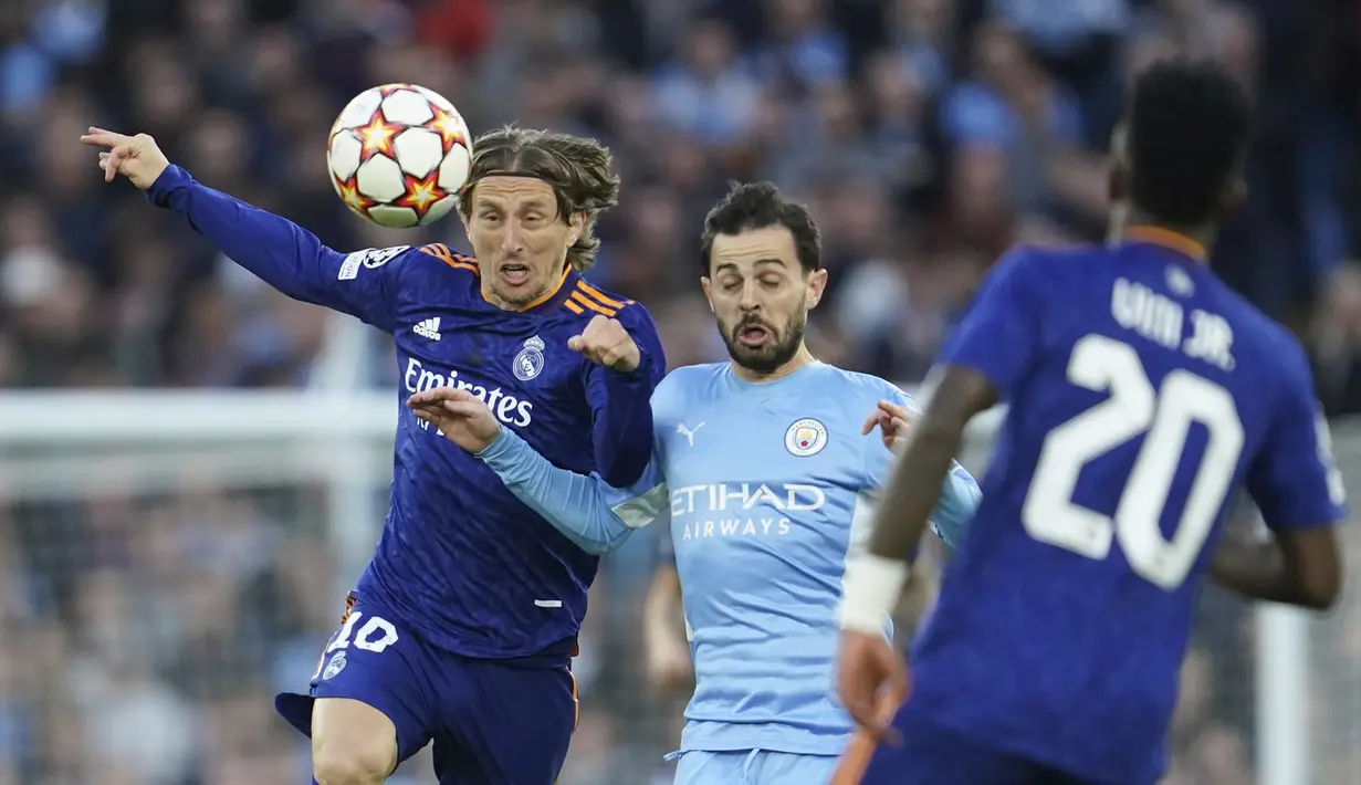 <p>Gelandang Real Madrid, Luka Modric berebut bola dengan gelandang Manchester City, Bernardo Silva pada pertandingan leg pertama semifinal Liga Champions di stadion Etihad di Manchester, Inggris, Rabu (27/4/2022). City menang atas Madrid 4-3. (AP Photo/Jon Super)</p>