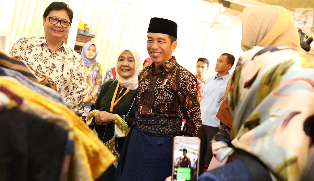 Presiden Joko Widodo atau Jokowi didampingi Menteri Perindustrian Airlangga Hartarto melihat-lihat busana saat menghadiri pembukaan Muslim Fashion Festival (Muffest) Indonesia Tahun 2018 di JCC, Kamis (19/4). (Liputan6.com/Immanuel Antonius)