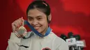 Peraih medali perunggu cabang olahraga bulu tangkis tunggal putri Olimpiade Paris 2024, Gregoria Mariska Tunjung berfoto dengan medali yang diraihnya di Istana Merdeka, Jakarta, pada Kamis 15 Agustus 2024. (BAY ISMOYO/AFP)