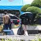 Warga menggunakan payung untuk menghidari paparan sinar matahari saat jalan di kawasan Bundara Hi, Jakarta, Jumat (14/4/2023). (Liputan6.com/Faizal  Fanani)