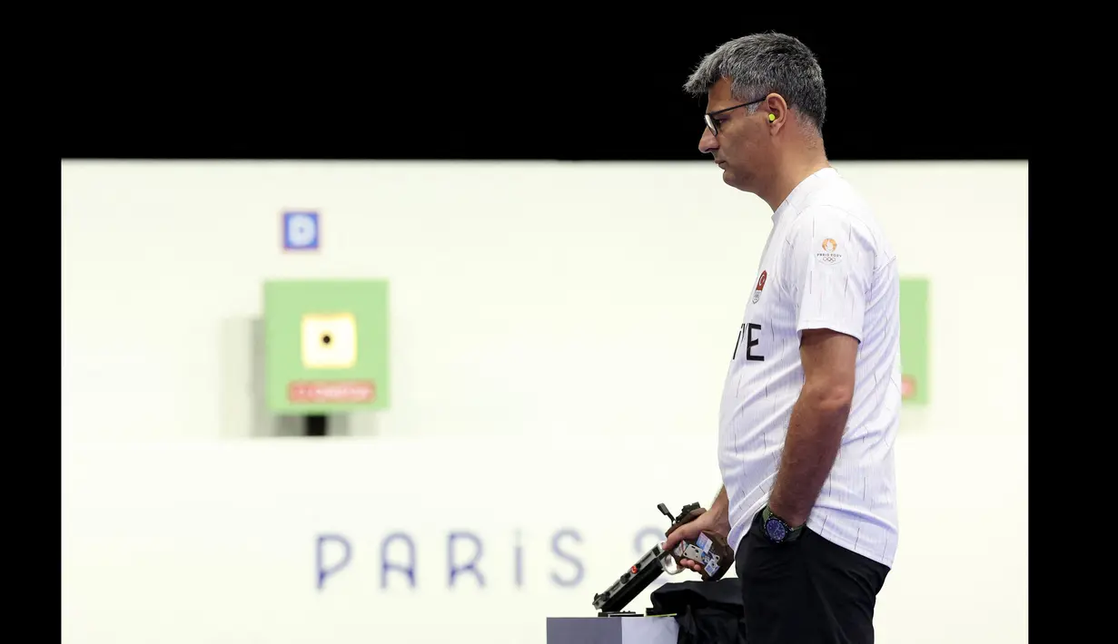 Penembak Turki, Yusuf Dikec bersiap saat bertanding dalam cabang olahraga menembak nomor 10m Air Pistol beregu campuran Olimpiade Paris 2024 di Chateauroux Shooting Centre, Paris, Prancis, Rabu (30/07/2024). (AFP/Alain Jocard)