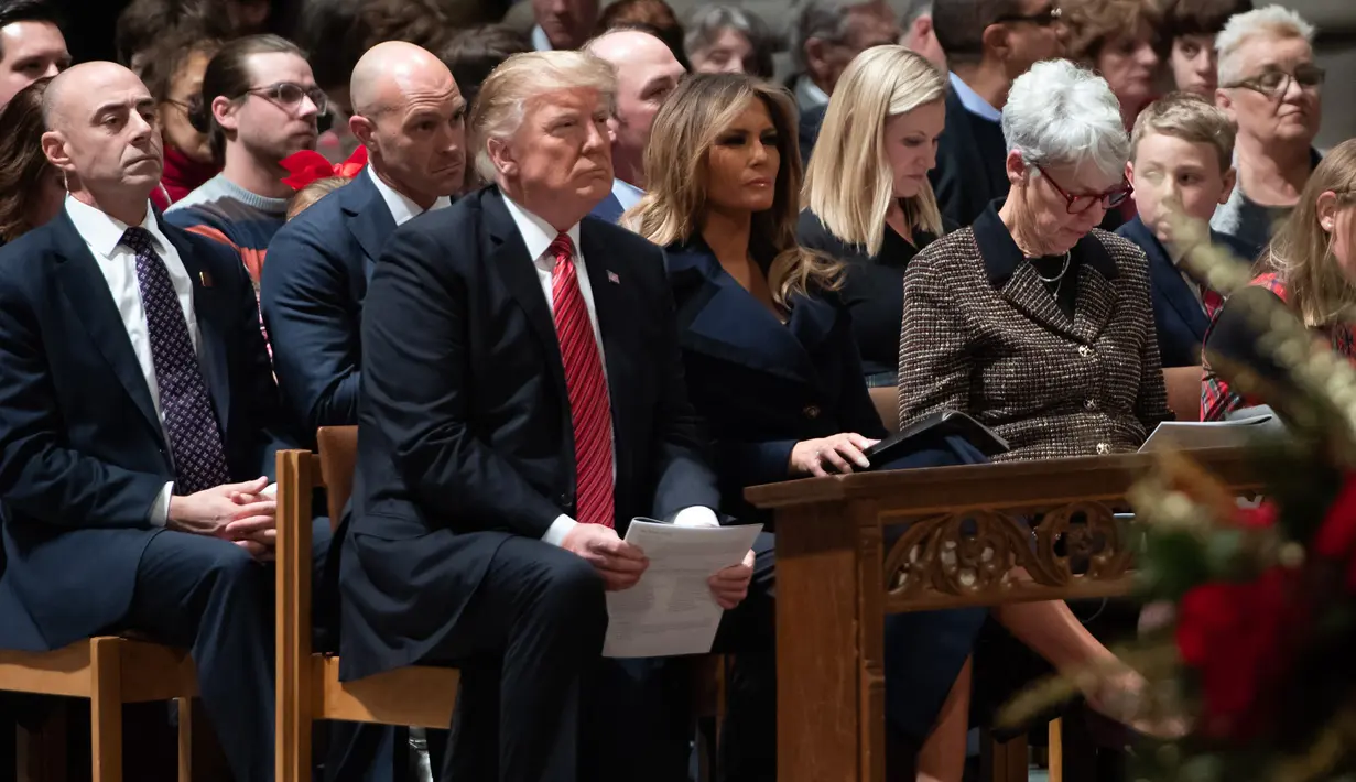 Presiden AS Donald Trump dan Ibu Negara Melania Trump menghadiri Misa Malam Natal di Washington National Cathedral di Washington, DC, (24/12). (AFP Photo/Saul Loeb)