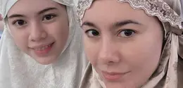 Wulan Guritno tampil mengenakan mukena shining coklat bermotif dengan wajah barefacenya. Tampak sang putri tercinta mendampinginya. [@wulanguritno]