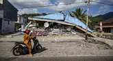 Sebuah sepeda motor berhenti di dekat bangunan yang runtuh pascagempa berkekuatan magnitudo 7,7 di Borong, Manggarai Timur, Nusa Tenggara Timur, Minggu, 16 Agustus 2026.. (AFP/ Juni Kriswanto)