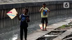 Anak-anak bermain layang-layang di pinggir kali Jalan Inspeksi Jakarta Barat, Rabu (12/7/2023). Meski berbahaya, mereka tetap menikmati bermain di pinggir kali tersebut. (Liputan6.com/Johan Tallo)