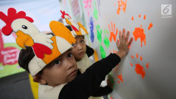 Anak-anak memberikan cap tangan yang dibaluri cat pada Festival Gizi Anak yang digelar Danone Nutricia, Bogor, Selasa (30/1). Kegiatan edukasi gizi ini digelar dalam rangka Hari Raya Gizi Nasional yang jatuh pada 25 Januari 2018 lalu. (Liputan6.com)