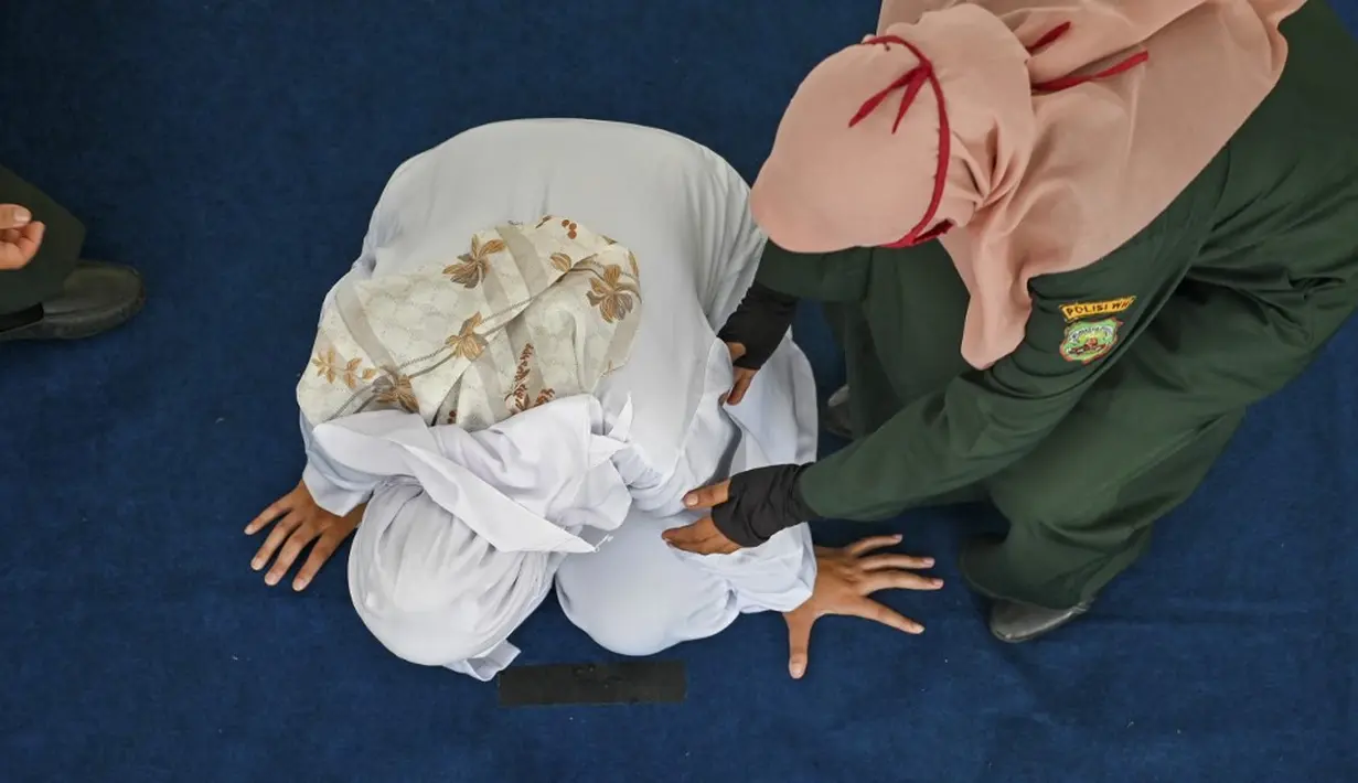 <p>Prosesi uqubat cambuk terhadap pelaku perzinaan yakni laki-laki M (24) warga Aceh Besar dan perempuan RO (23) warga Aceh Tengah itu berlangsung berdasarkan putusan Mahkamah Syariah Banda Aceh. Masing-masing pelaku menerima hukuman cambuk sebanyak 25 kali, lalu dikurangi masa tahanan sementara yang telah dijalani selama 4 bulan atau 91 hari (kurungan). (CHAIDEER MAHYUDDIN/AFP)</p>