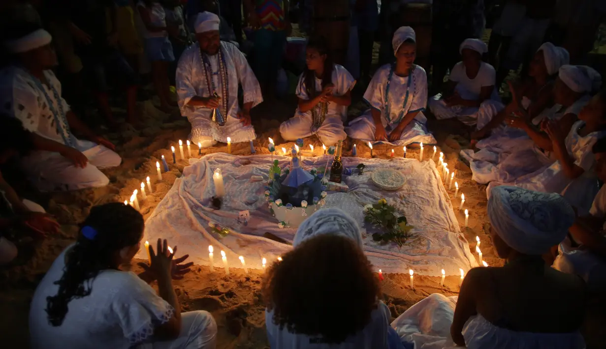 Pengikut kepercayaan Candomble Afro-Brasil menggelar ritual menyalakan lilin sebelum fajar saat perayaan Dewi Laut Yemanja di Salvador, Brasil (2/2). Mereka memberikan hadiah ke laut untuk persembahan kepada Dewi Laut Yemanja. (AP Photo / Eraldo Peres)