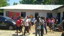 Penduduk desa berdiri di luar sebuah gedung setelah gempa bumi berkekuatan 7,3 SR mengguncang lepas pantai di Maumere di Nusa Tenggara Timur di pulau Flores, Selasa (14/12/2021). (AFP/Yanuarius Arlino Welianto)